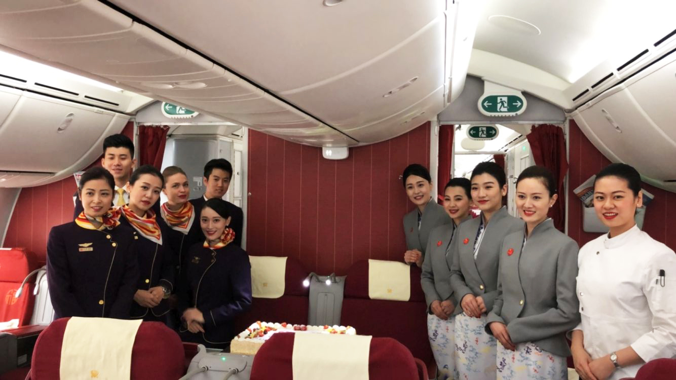 ทีมลูกเรือ Hainan Airlines ยืนถ่ายรูปรวมกันในห้องโดยสาร